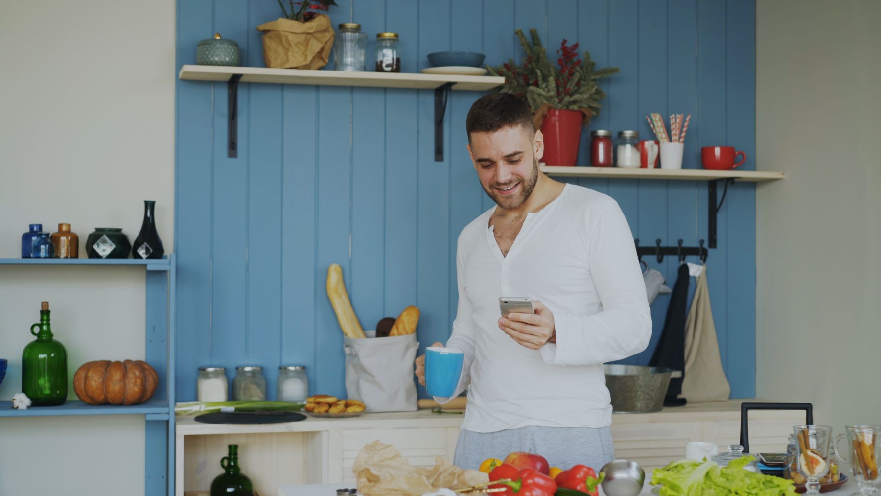 A young man with his morning coffee, checking his phone