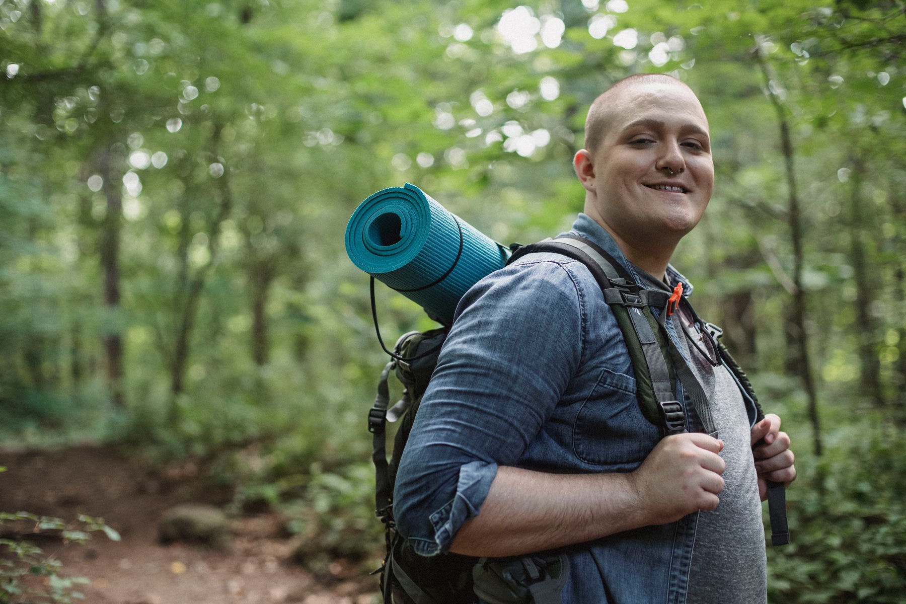 A man smiling on a woodland walk
