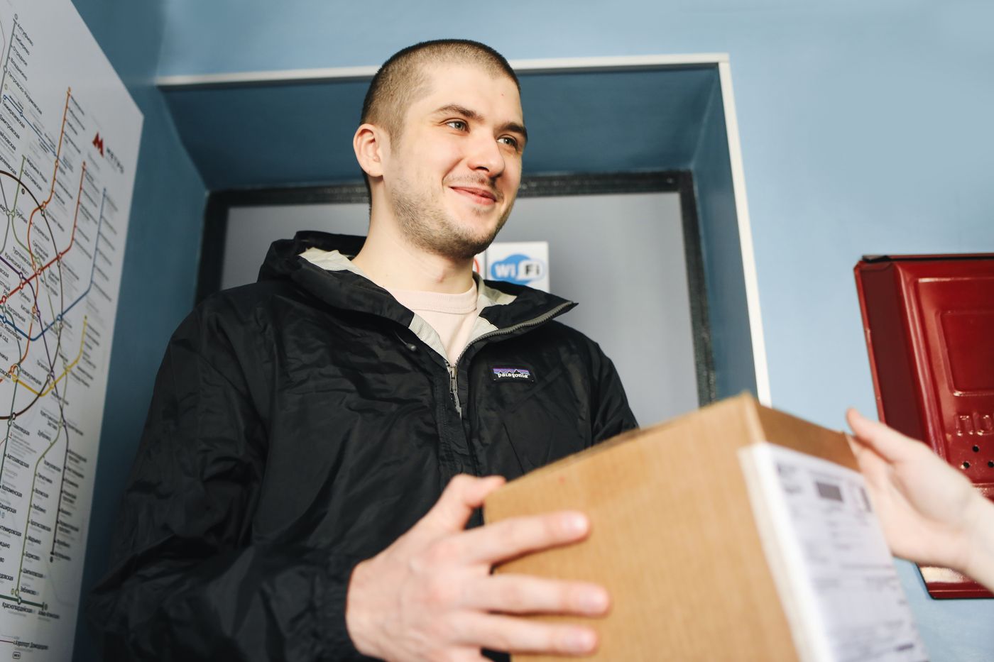 A smiling man receiving his parcel at home