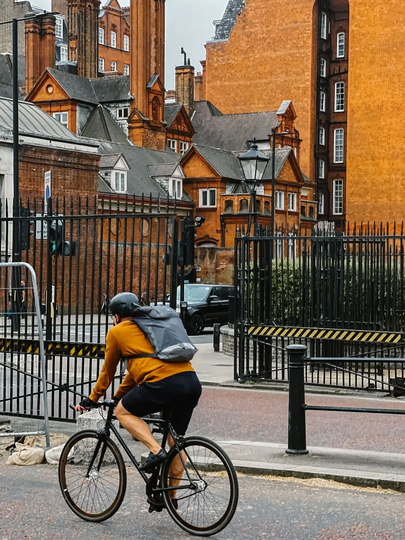 A cyclist riding past red-brick buildings in central London