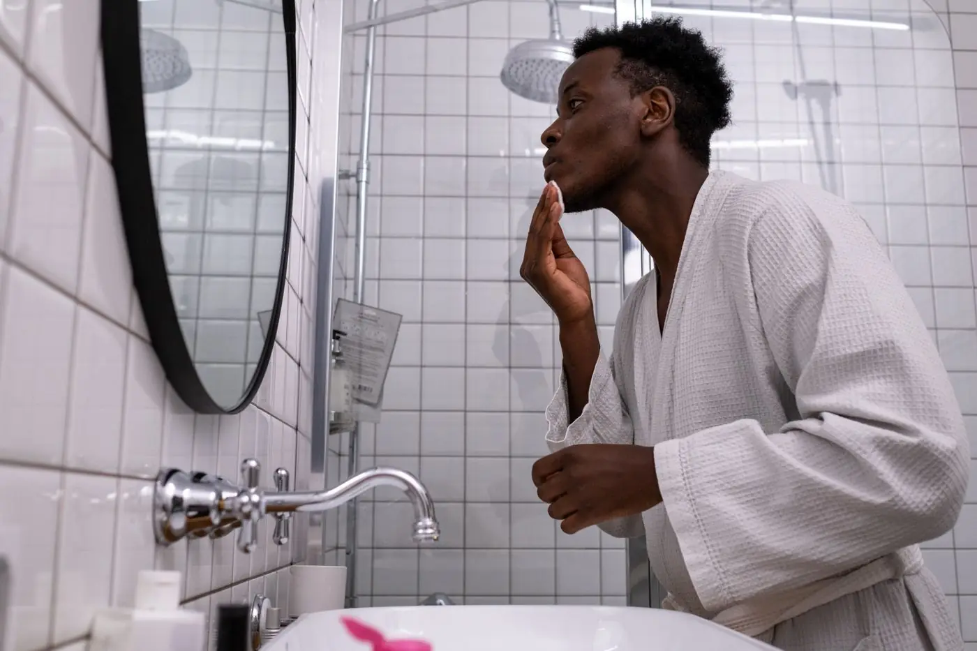 A man looking after his skin at the bathroom mirror