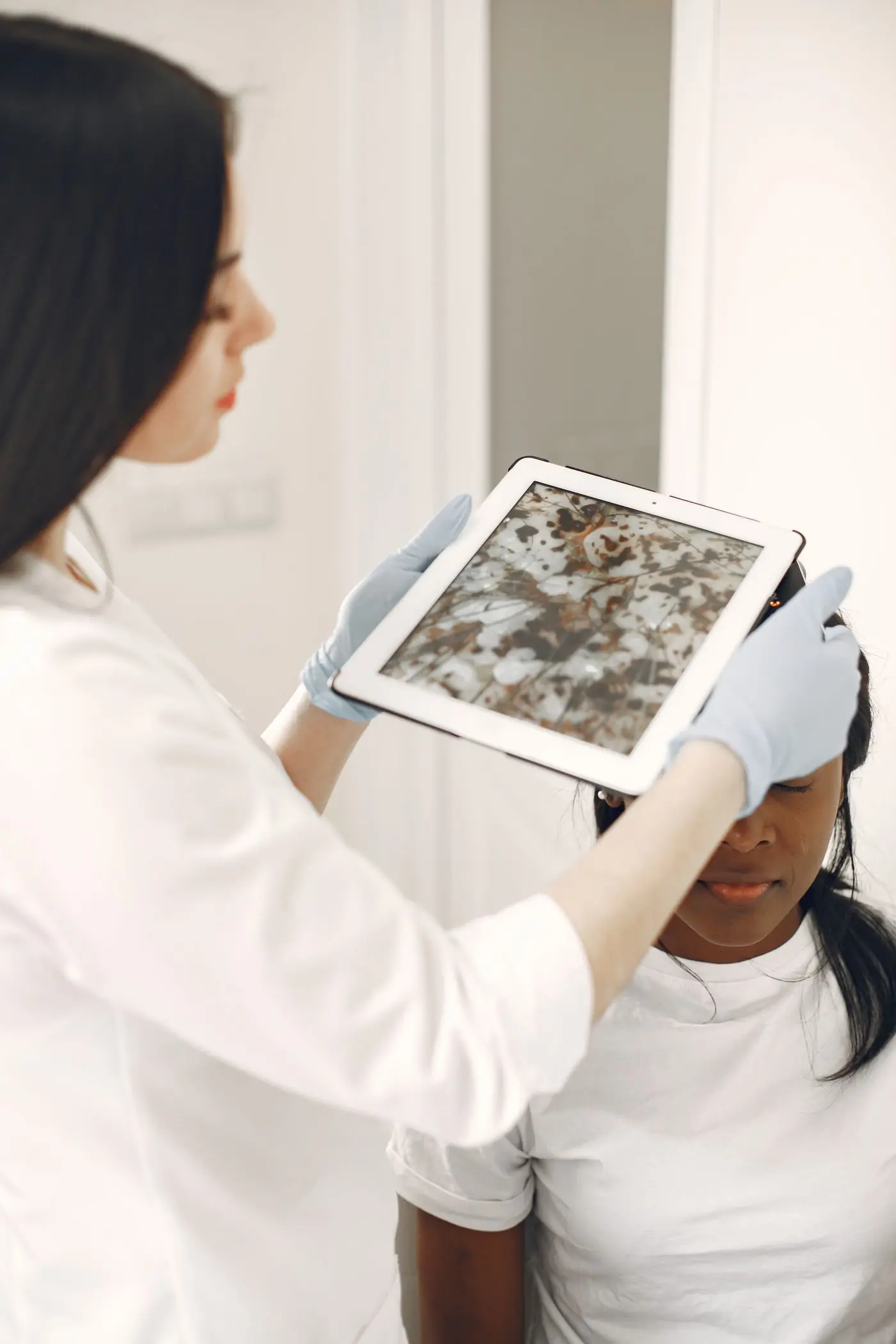 A dermatologist reviewing a skin image on a tablet