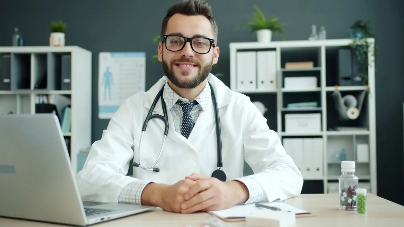 A smiling doctor at his desk