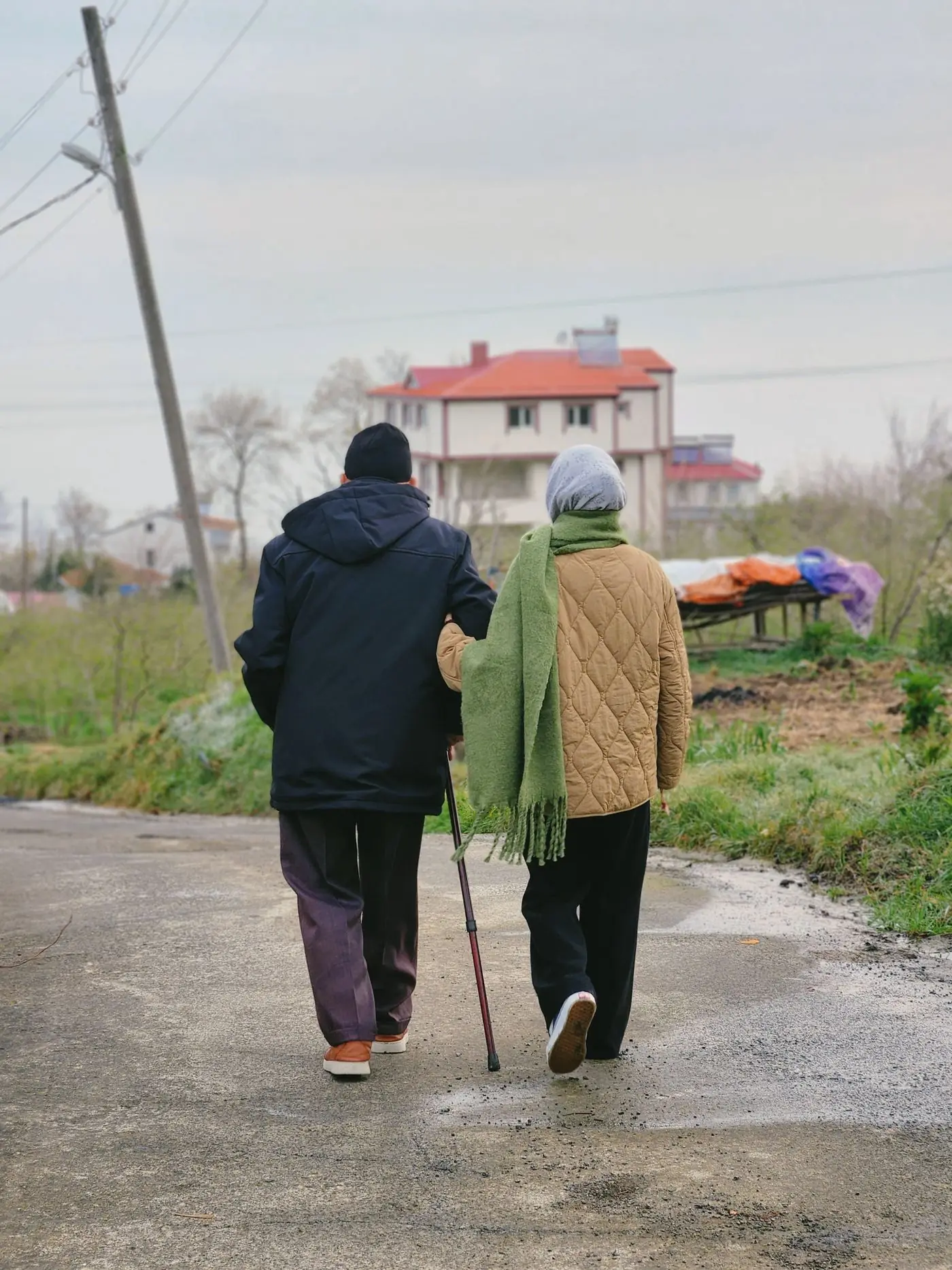 An older couple walking together along a country lane