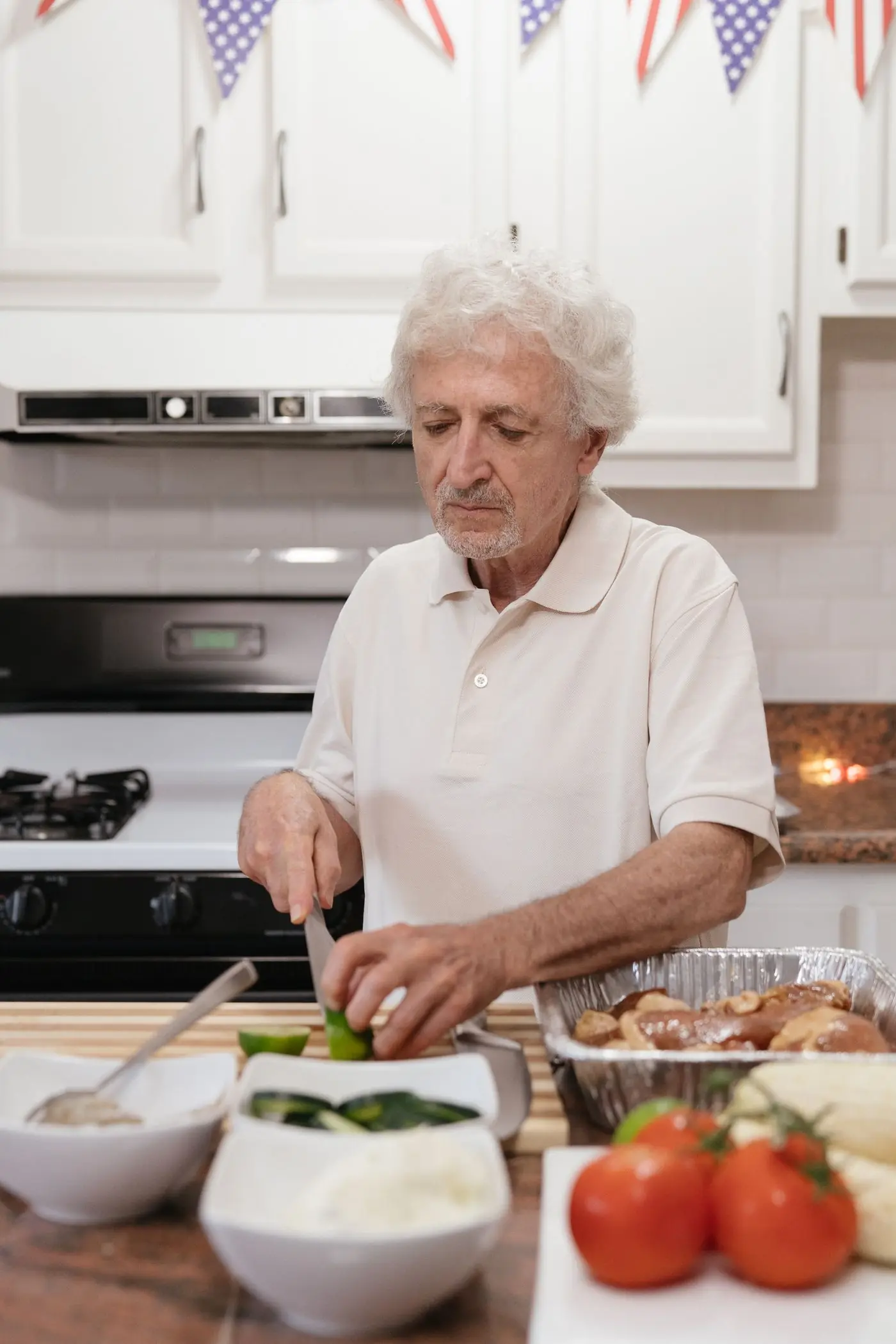 A smiling older man preparing a fresh meal at home