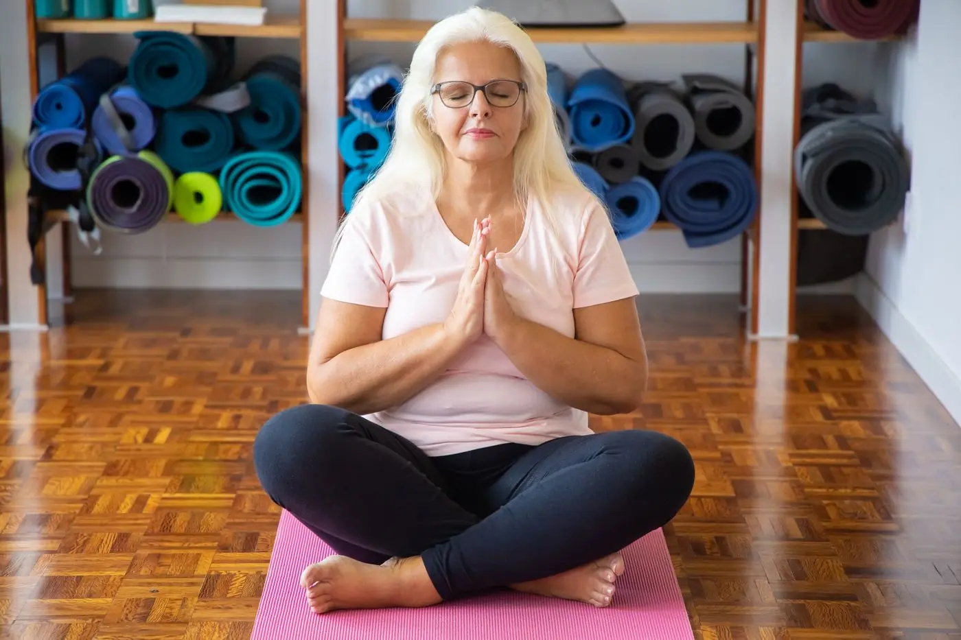 A smiling older woman doing yoga