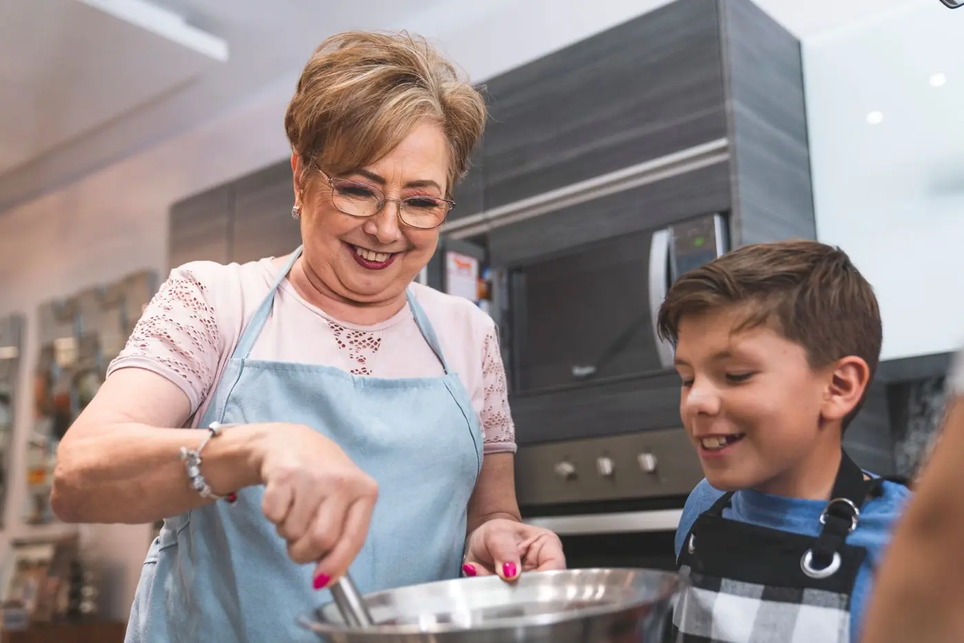 A grandmother cooking with her grandson at home