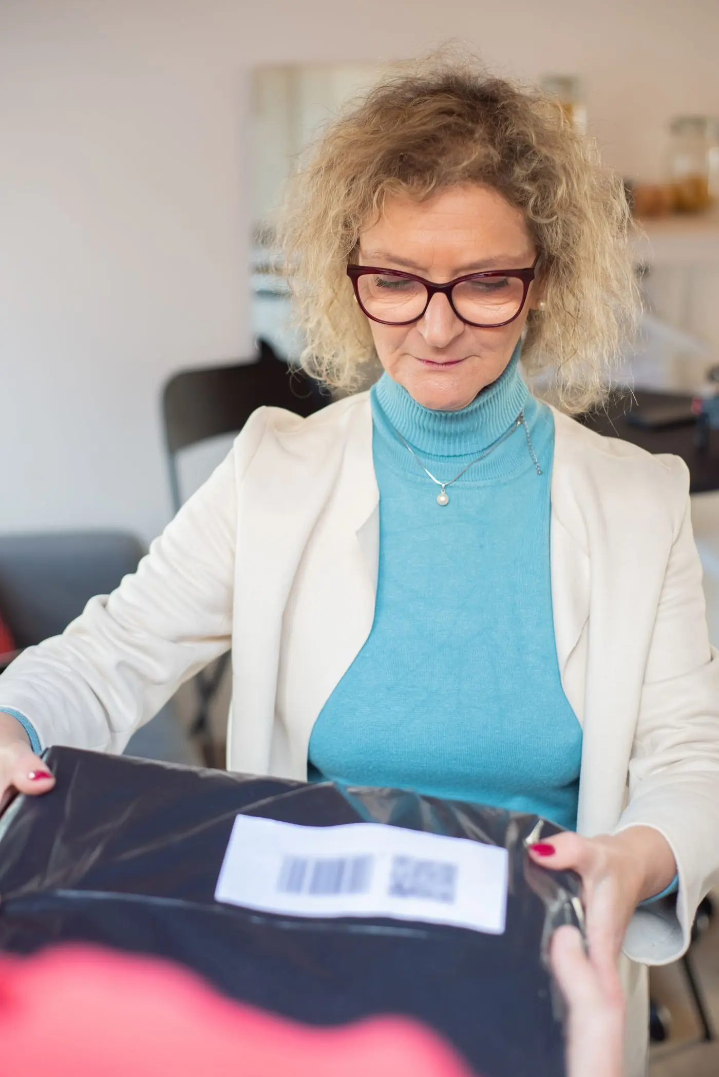 A smiling woman receiving her parcel at home