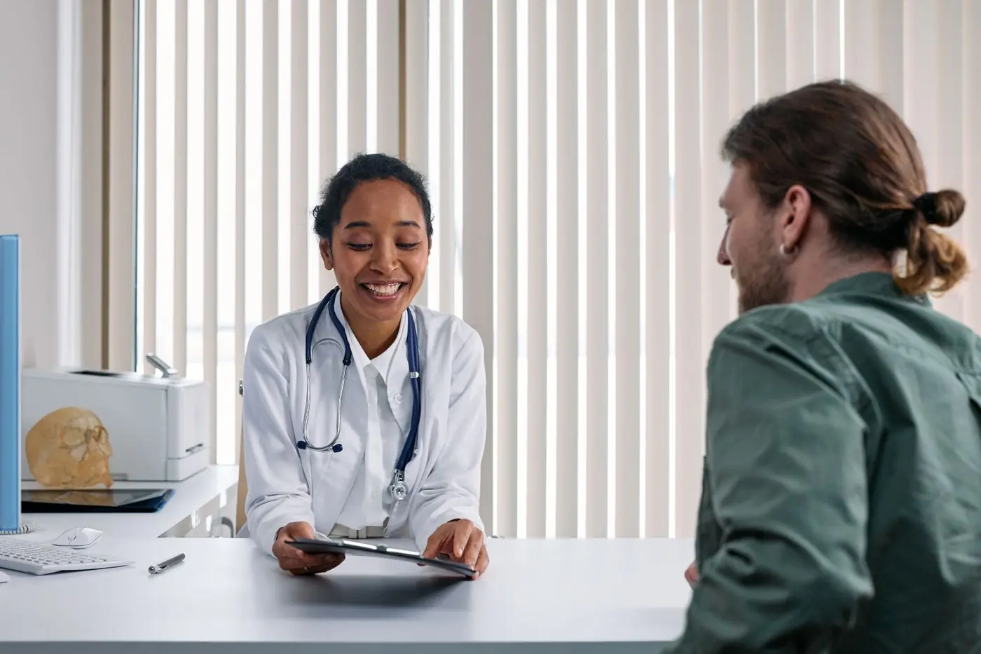 A doctor smiling with a male patient during a consultation